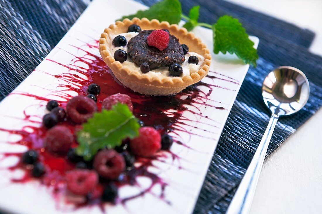 A tartlet with mascarpone-marsala cream, chocolate-amaretto dough and berries