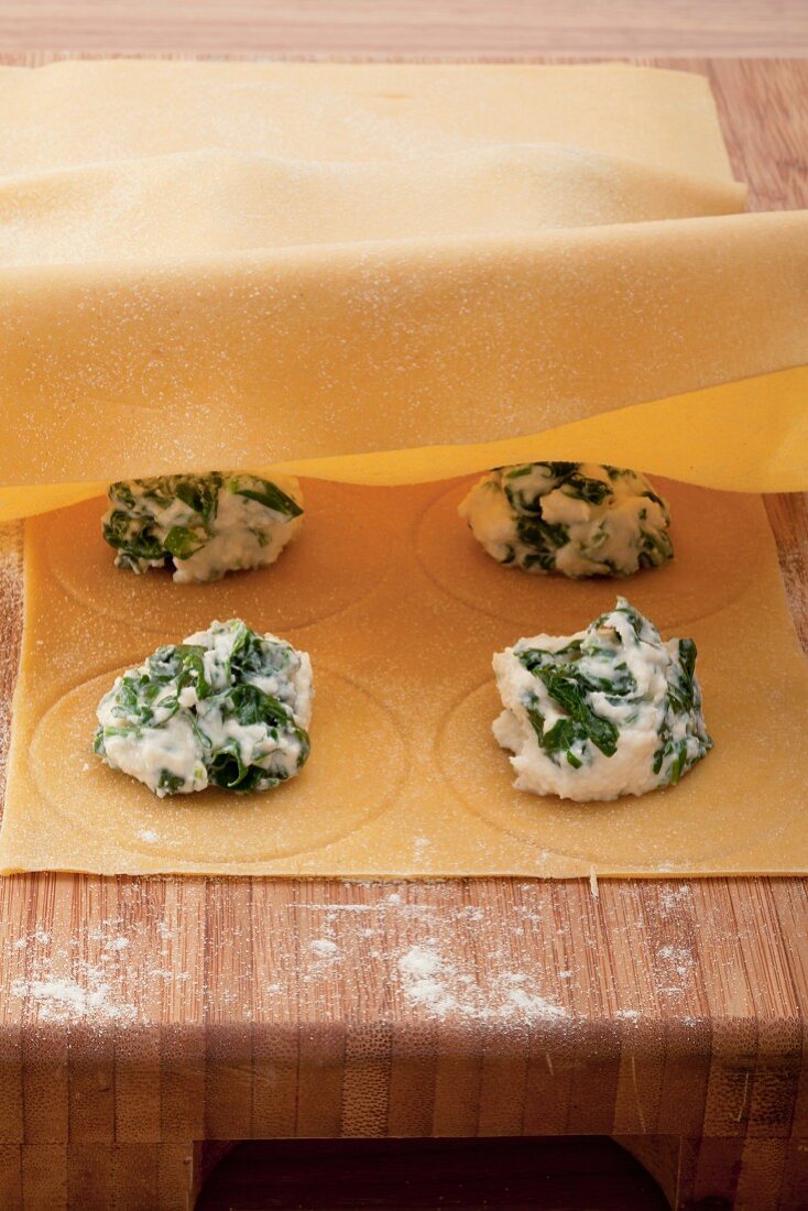 Round ravioli filled with ricotta and herbs being made