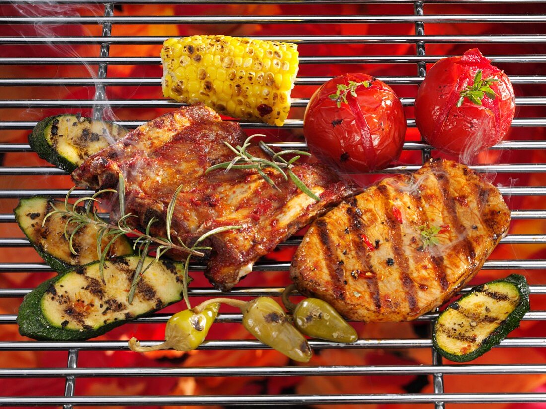 Spare ribs, steak and vegetables on a grill