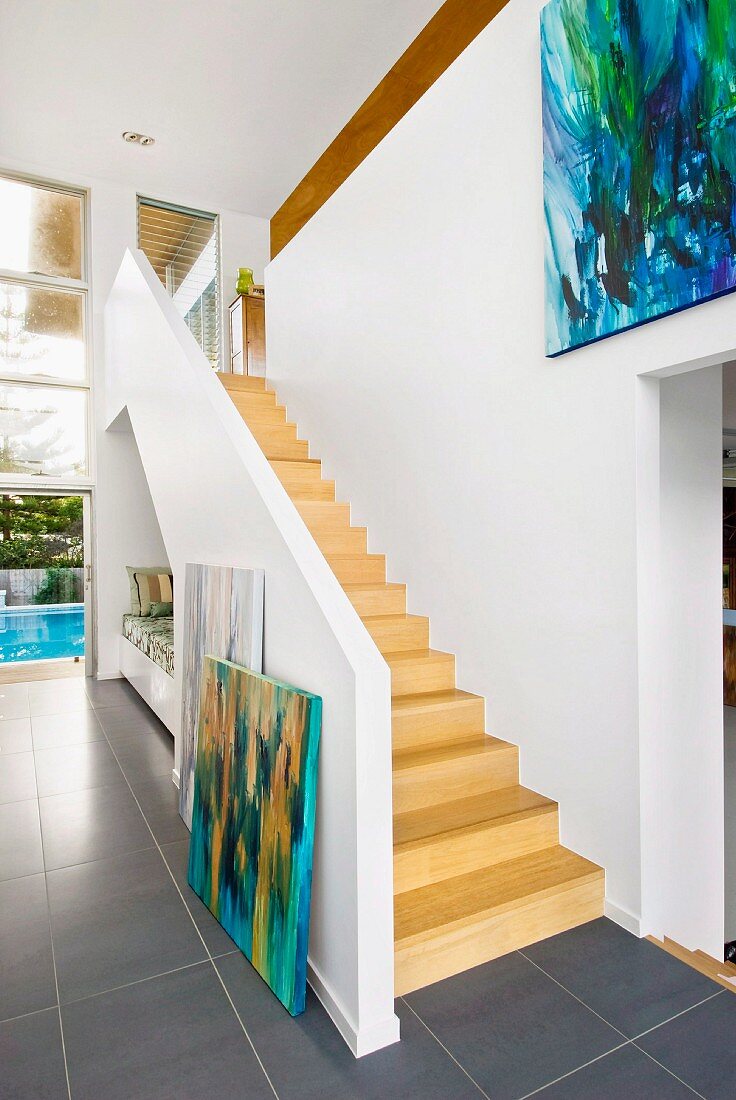 Offener Vorraum mit Treppenaufgang aus Holz und Blick auf Galerie in zeitgenössischer Architektur