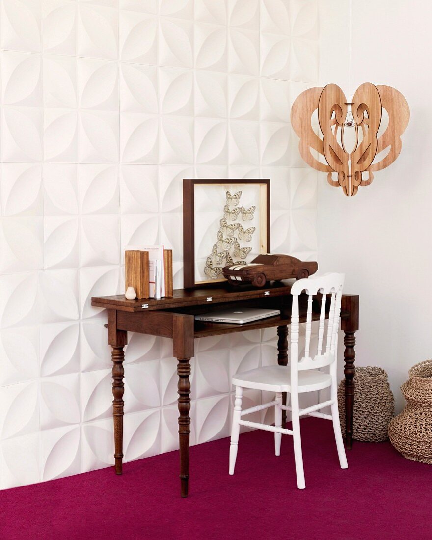 Antique bureau and white chair against white, three dimensional wall panels and on purple carpet