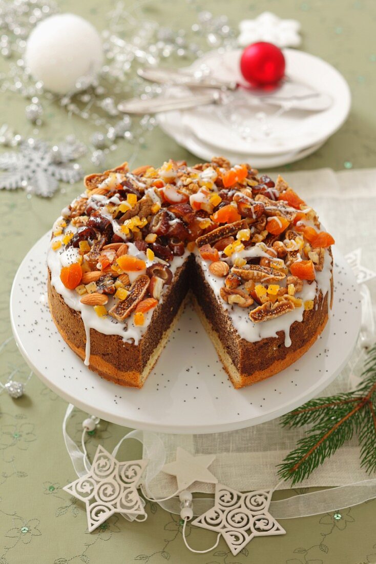 Poppy seed cake with icing, dried fruits and nuts for Christmas