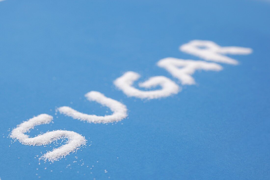 The word SUGAR written on a blue surface