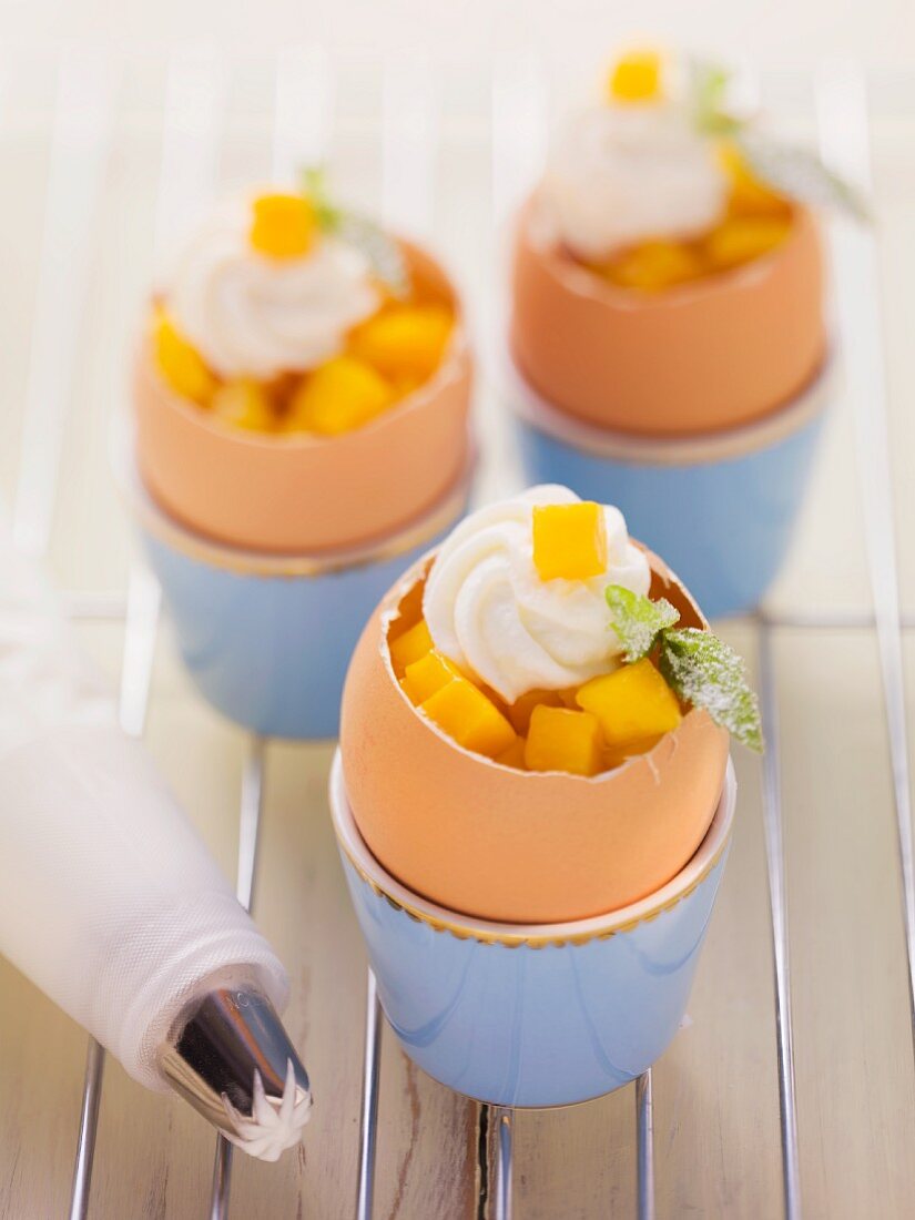 Carrot cakes baked in egg shells and garnished with mango and quark cream