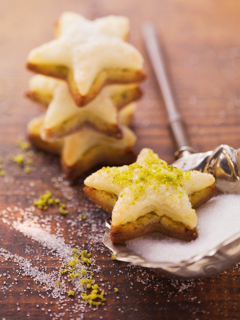 Star-shaped biscuits topped with marzipan and pistachios