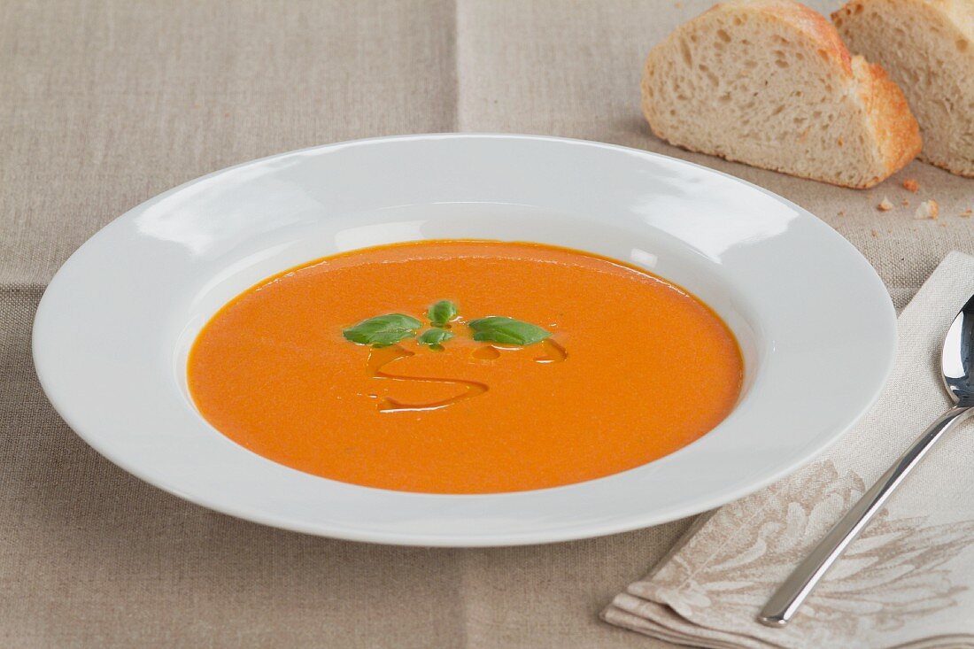 Cream of tomato soup garnished with olive oil and basil