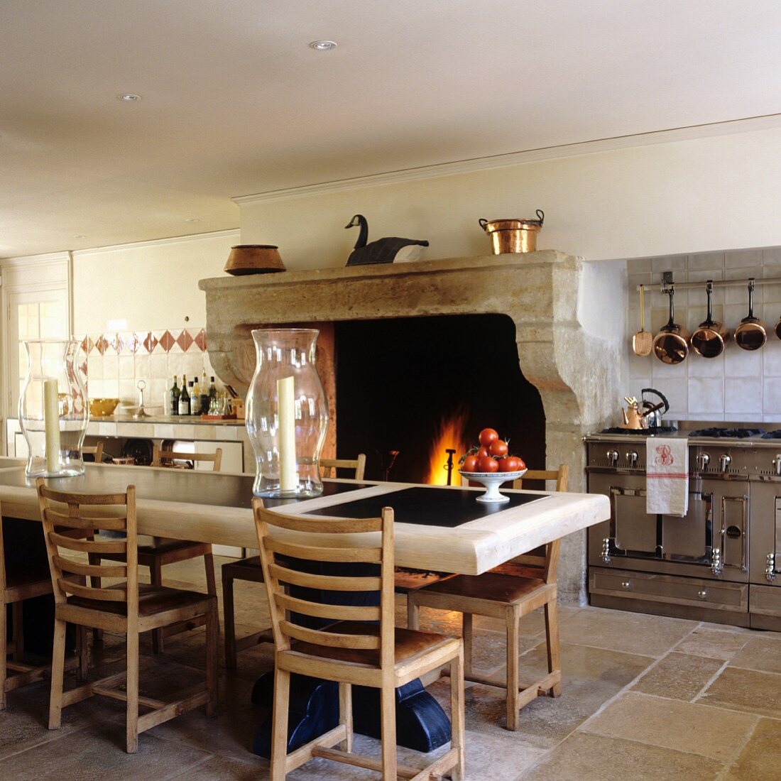 Vintage kitchen with dining table in front of open fireplace in Mediterranean country house