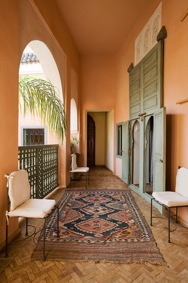 Orientteppich auf Parkett mit Fischgrätmuster in Loggia eines marokkanischen Wohnhauses