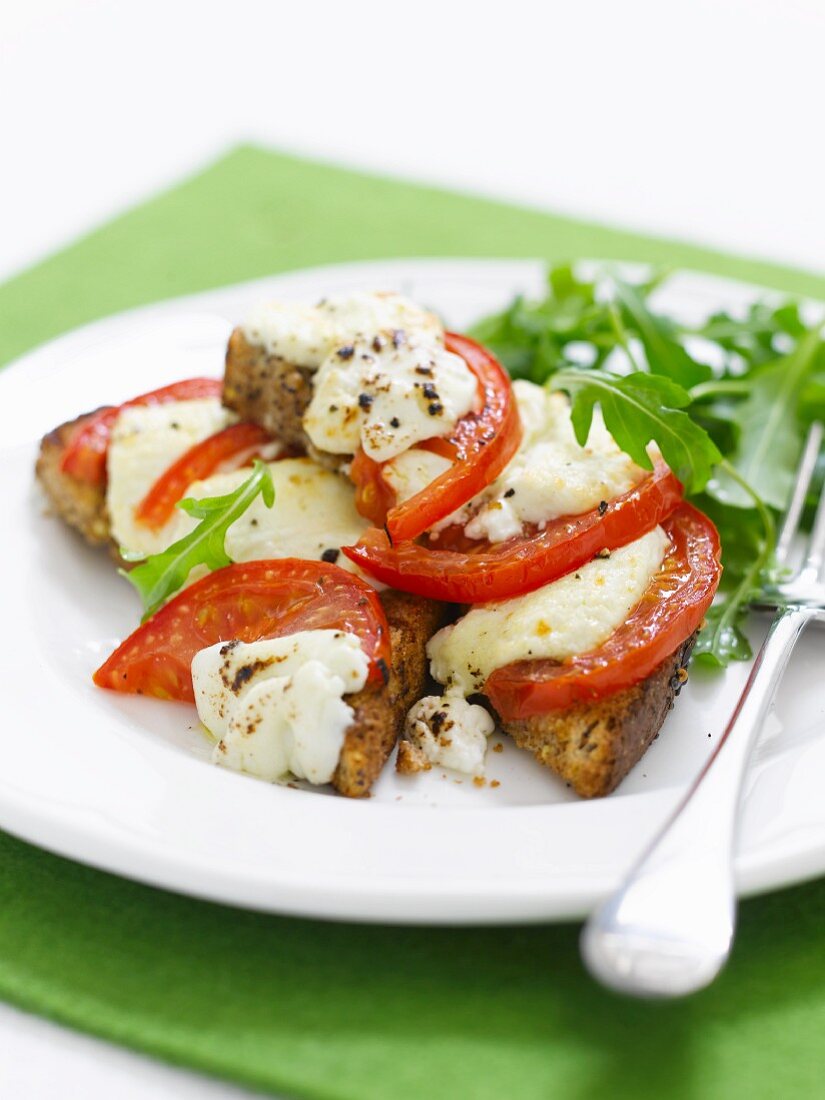 Toast topped with tomatoes, cheese and rocket