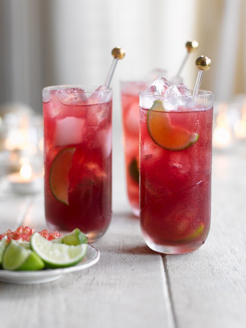 Pomegranate martinis with limes and ice cubes