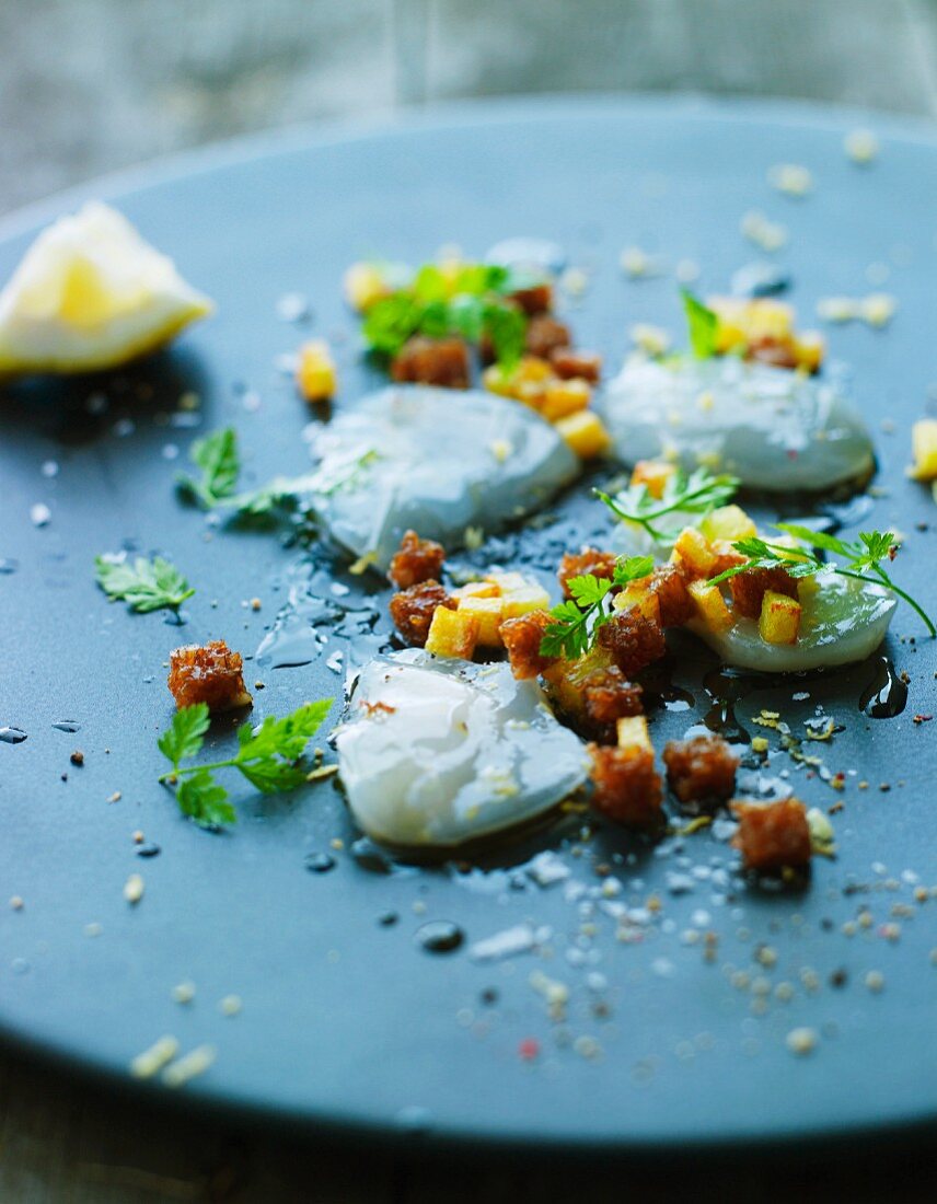 Jakobsmuchel-Carpaccio mit ausgelassenen Speckwürfeln