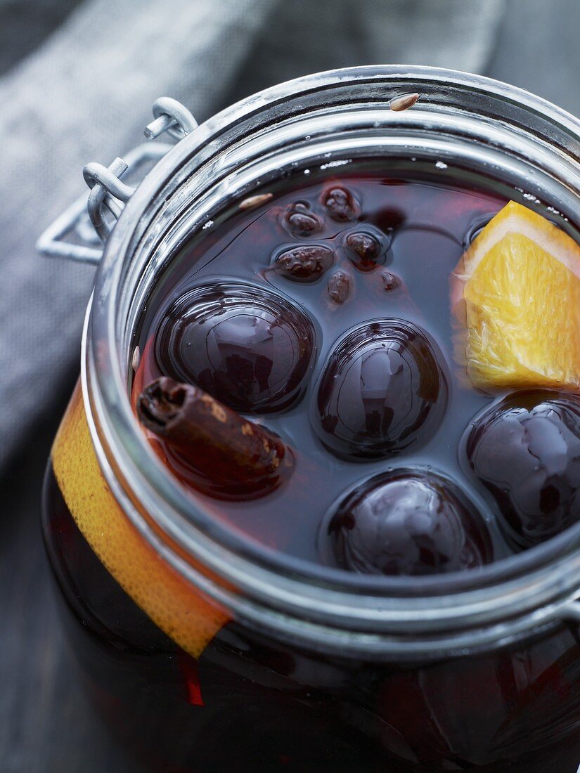 A jar of cherry compote with oranges