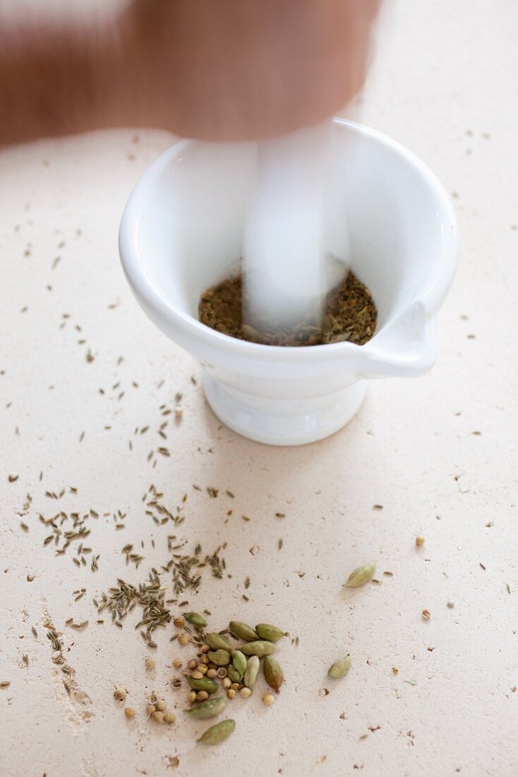 Indian spices being crushed in a mortar