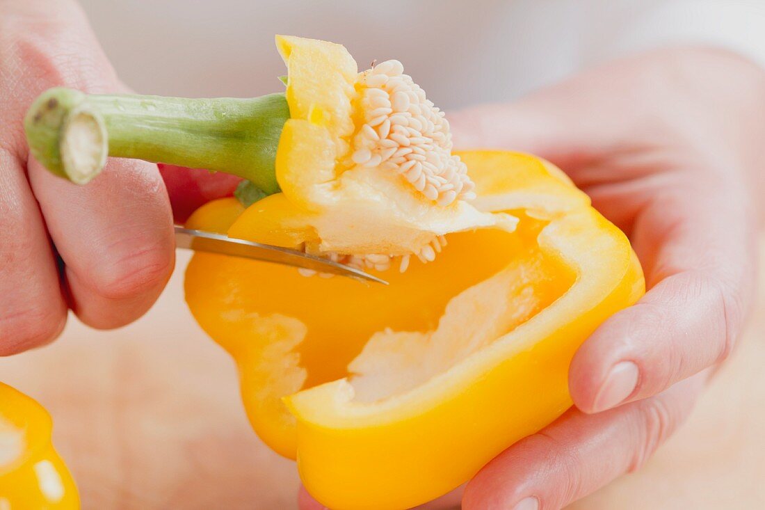The stalk being removed from a pepper