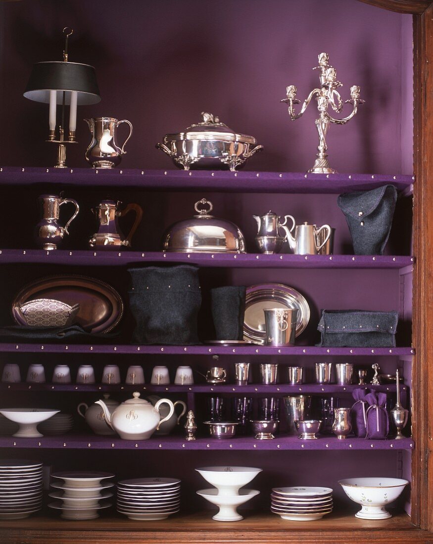 A cupboard filled with silverware and porcelain