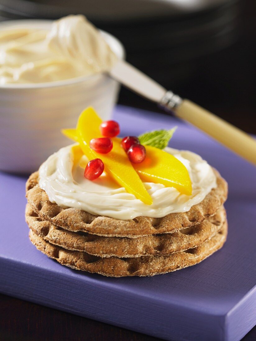 Knäckebrot mit Bel Paese, Mango und Granatapfelkernen