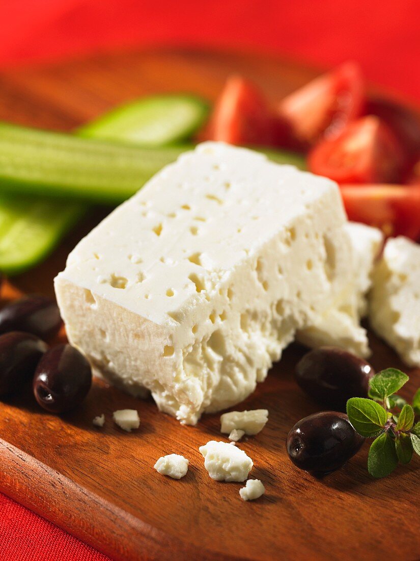 Feta, olives, cucumber and tomatoes on a chopping board