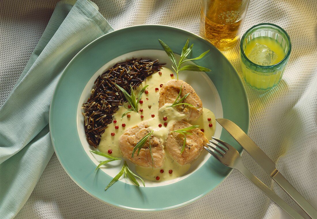 Salmon fillets in cream sauce with wild rice & red peppercorns garnish