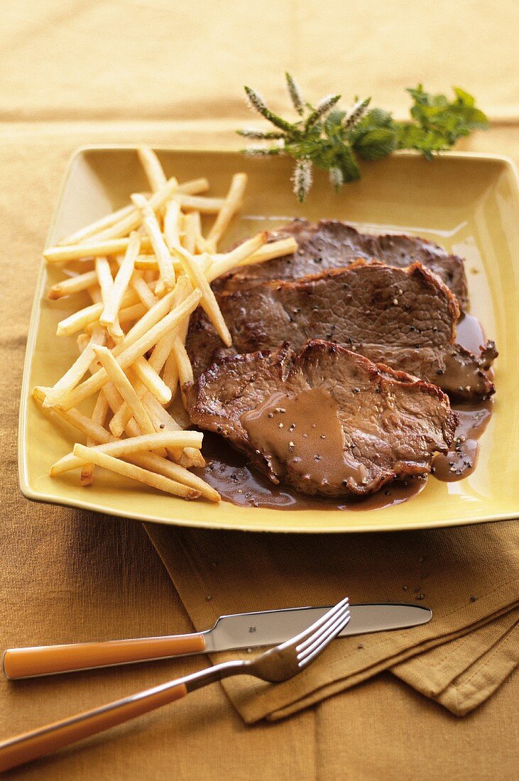 Rindersteak mit Pfeffersauce und Pommes frites