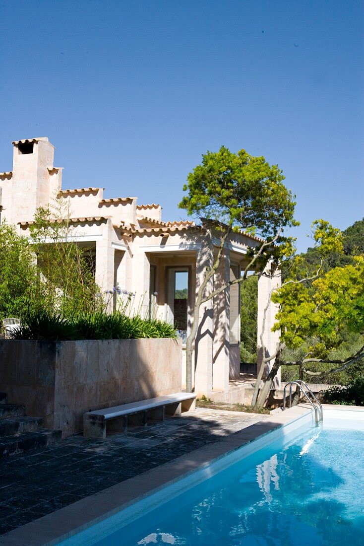 Swimming pool in garden in front of Mediterranean house