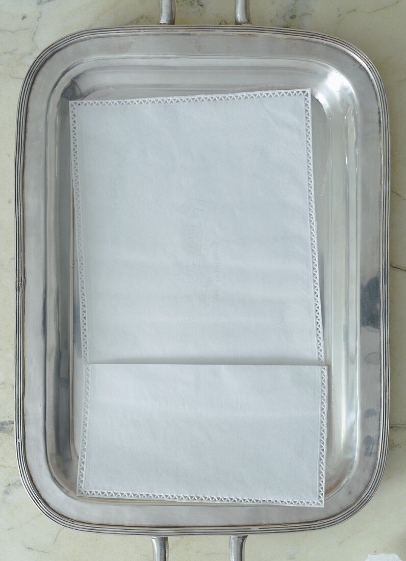 Silbertablett mit Serviette auf Marmortisch