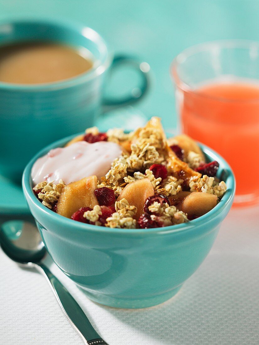 Muesli with apples, cranberries and yogurt, fruit juice and coffee