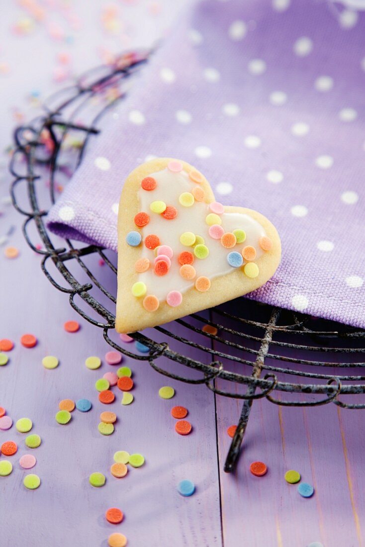 A heart-shaped biscuits with colourful sugar sprinkles