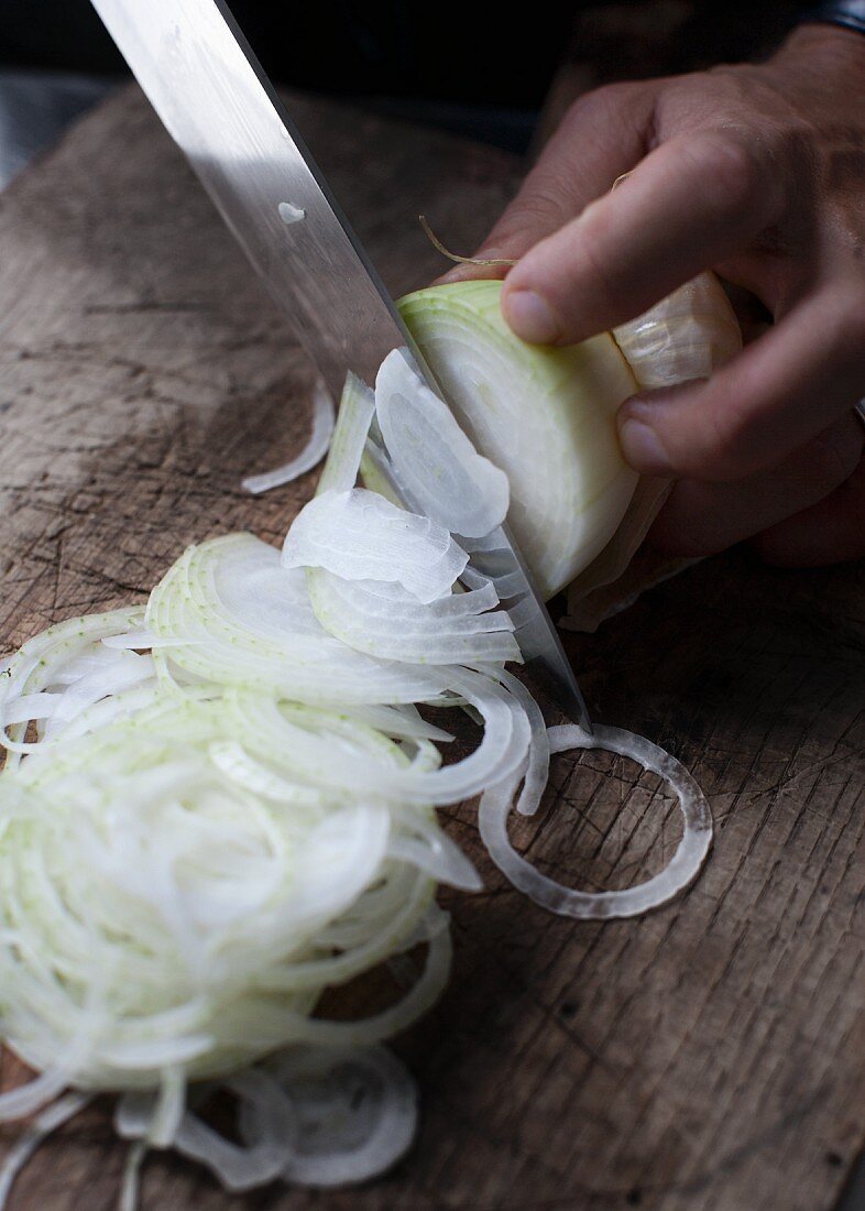 An onion being cut into rings