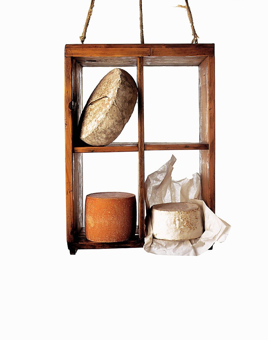 Three types of cheese in a wooden crate