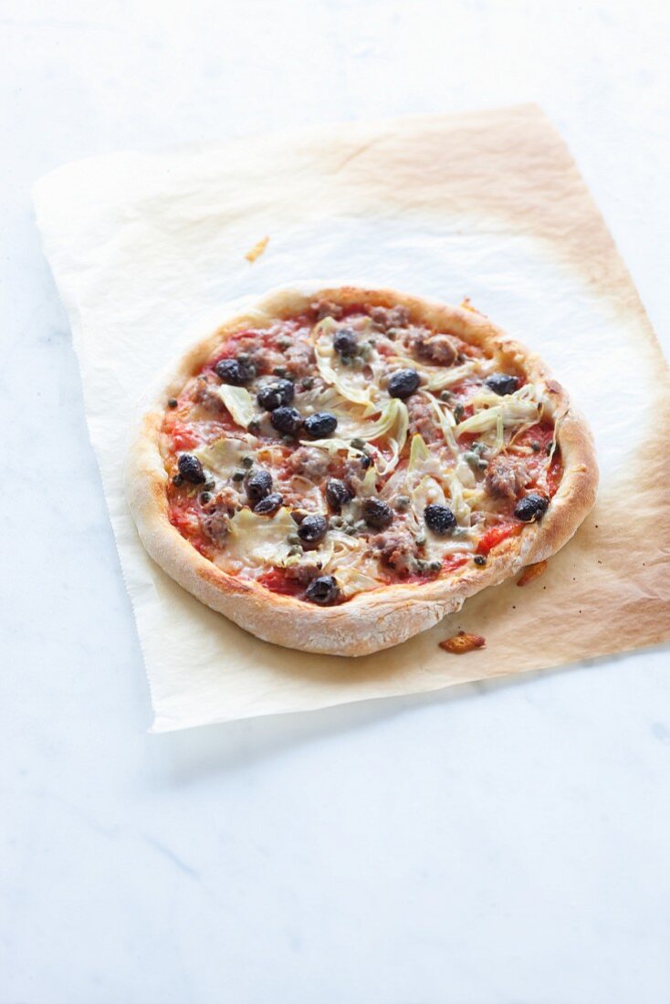 Pizza mit Salsiccia und schwarzen Oliven