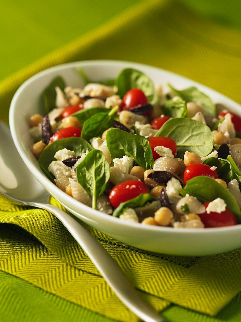 Pasta salad with chickpeas, baby spinach, tomatoes, olive and feta cheese