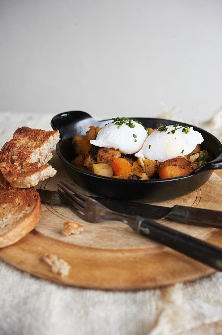 Poached Eggs Over Hash in a Cast Iron Skillet; Toast
