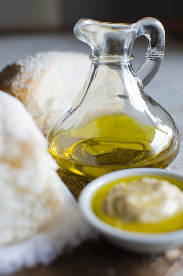 Olivenöl in Karaffe, Hummus in Schälchen & Weißbrot zum Dippen
