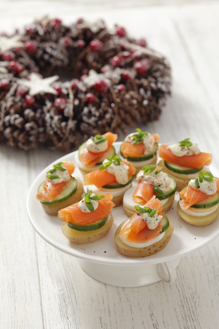 Potato slices topped with egg, cucumber and smoked salmon for Christmas
