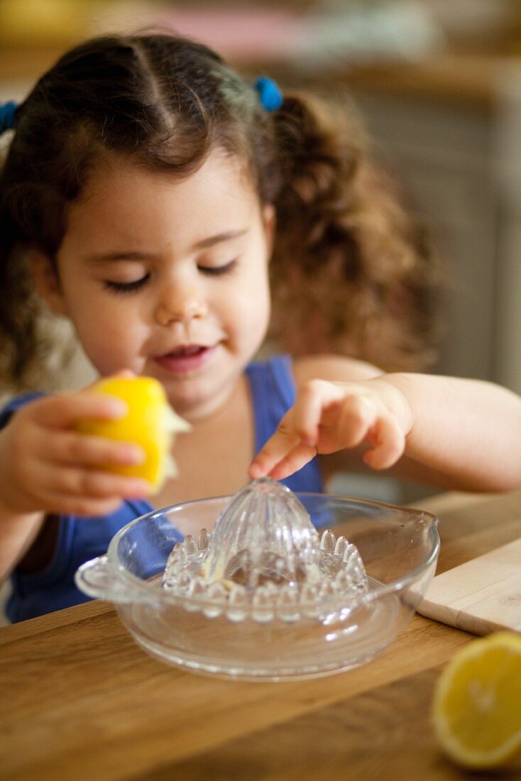 Kleines Mädchen presst Zitrone aus