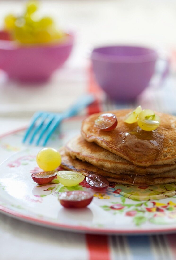 Pancakes with grapes and maple syrup