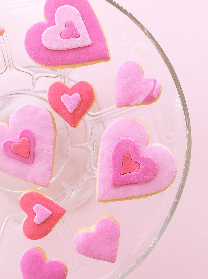 Pink heart-shaped biscuits on a glass plate