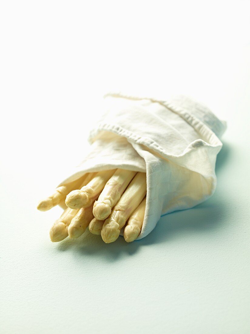 Peeled white asparagus wrapped in a cloth