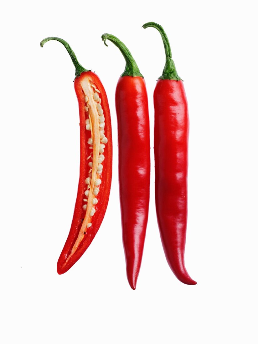 Chilli peppers, one sliced open, two whole