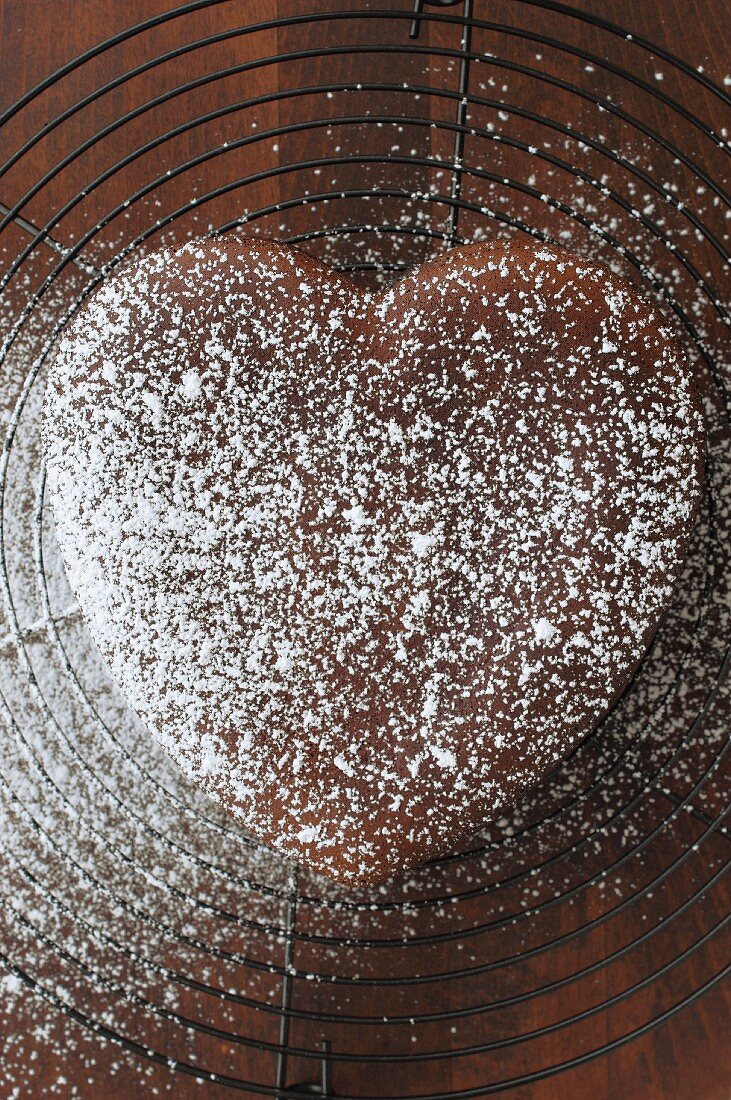 A heart-shaped chocolate cake dusted with icing sugar