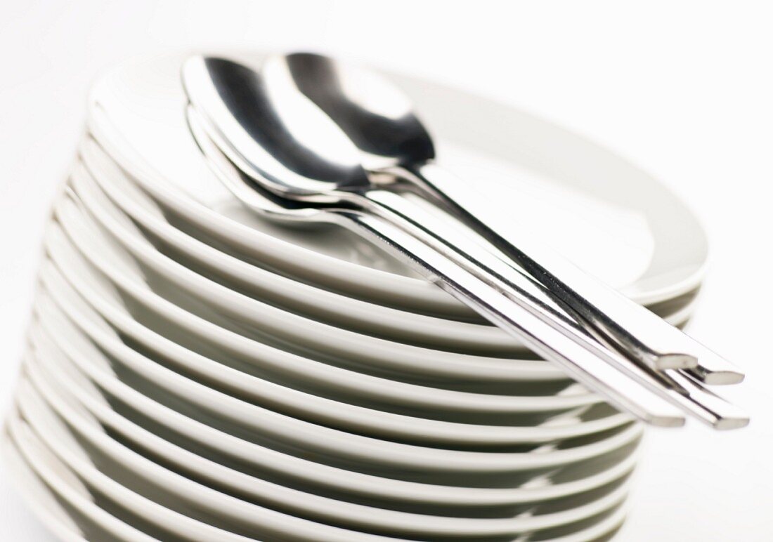 Stacked Plates with Spoons; White Background