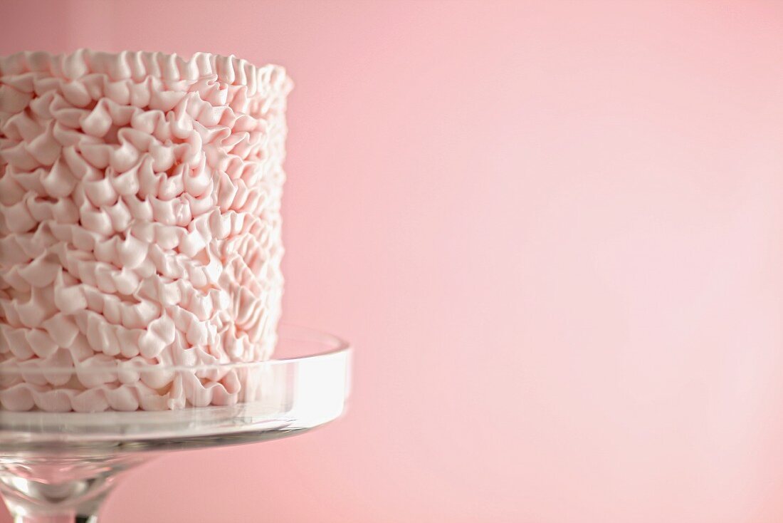 Cake Decorated with Ribbons of Pink Icing; On a Cake Plate