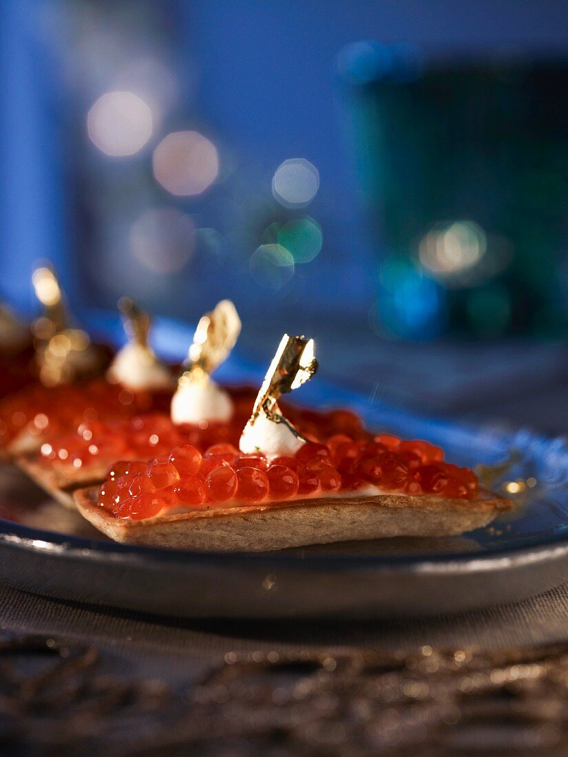Salmon caviar tartlets topped with gold leaf