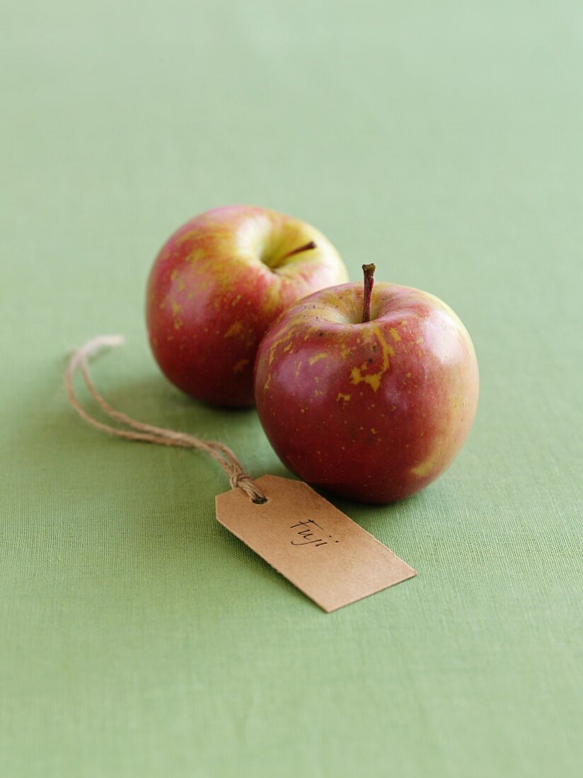 Zwei Fuji-Äpfel mit Etikett