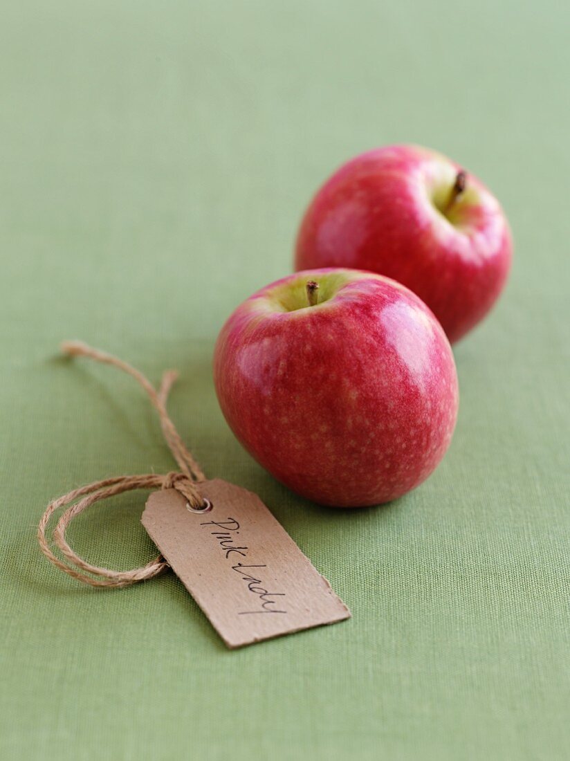 Two Pink Lady apples with a label