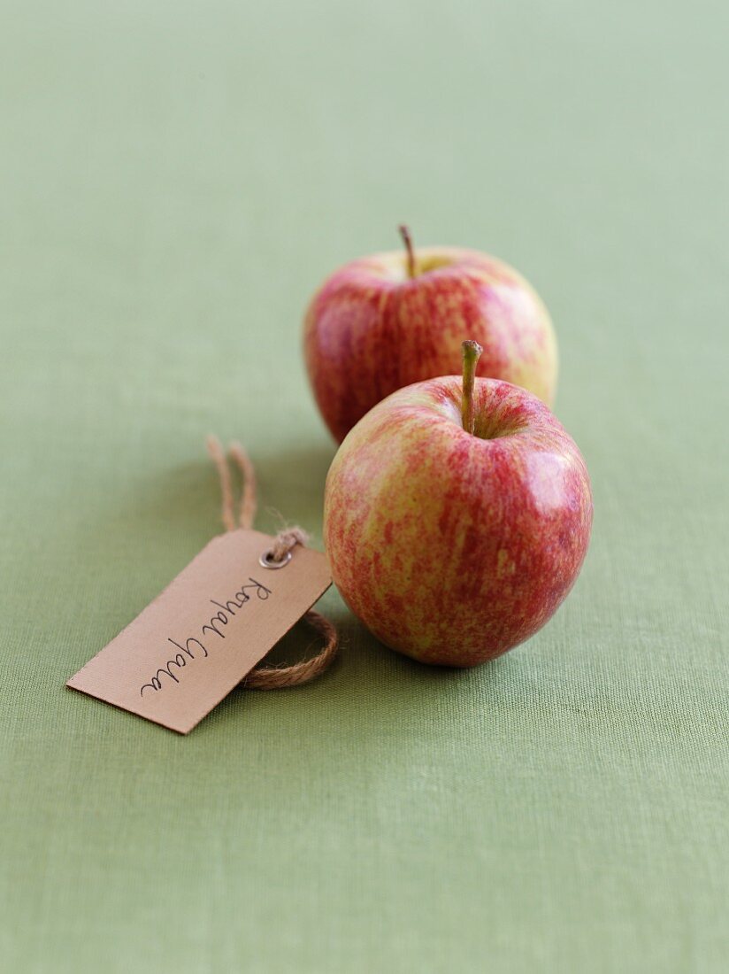 Two Royal Gala apples with a label