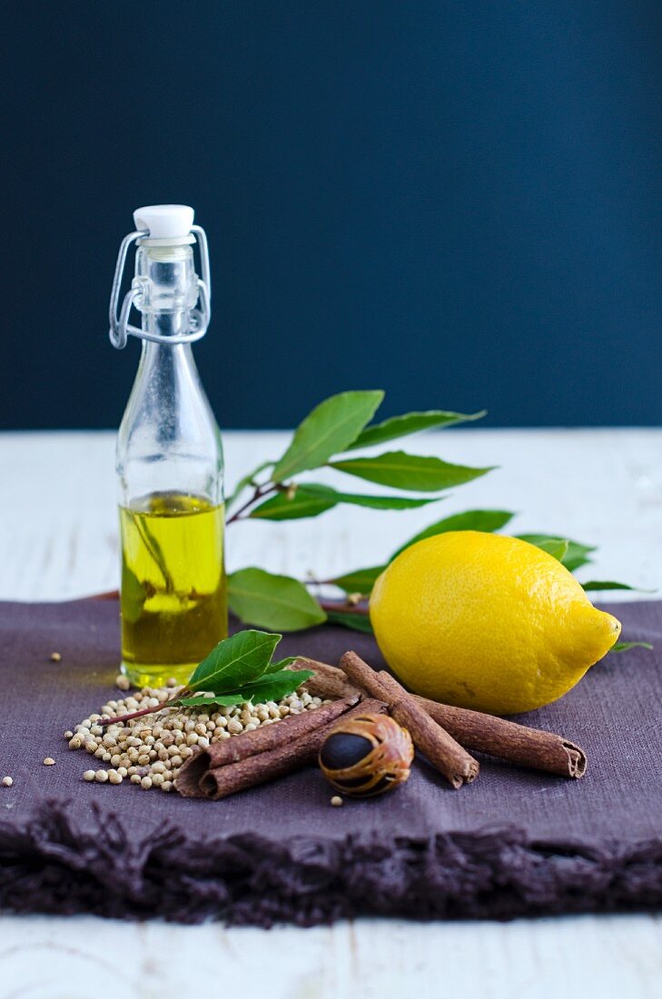 Spices, a lemon and olive oil (ingredients for aromatic oil)