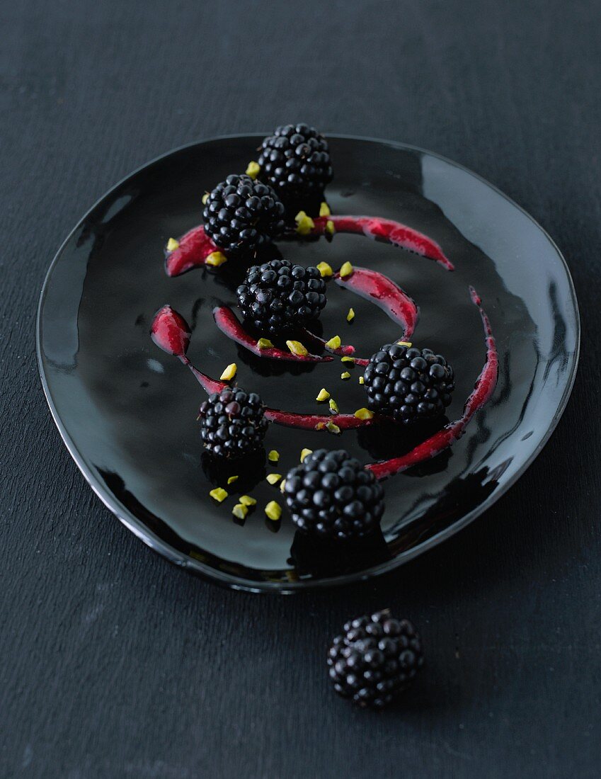 Blackberries with fruit sauce and chopped pistachios