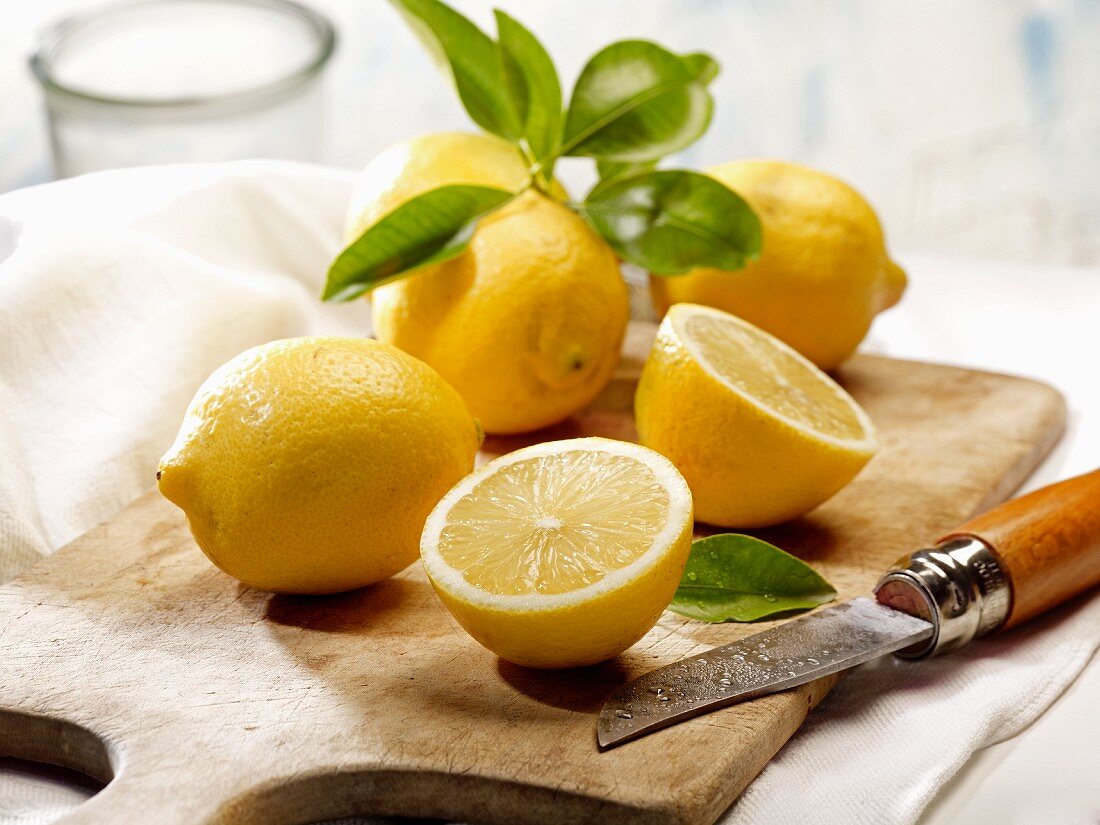 Zitronen mit Blättern und Messer