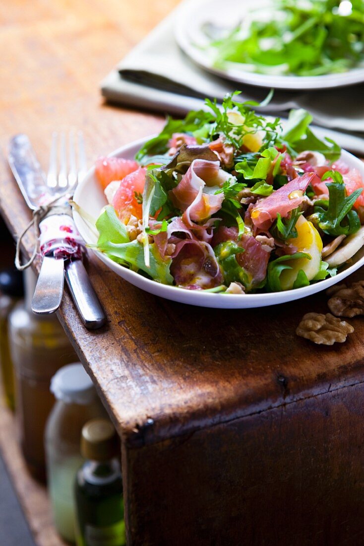 Garden salad with raw ham and fruit